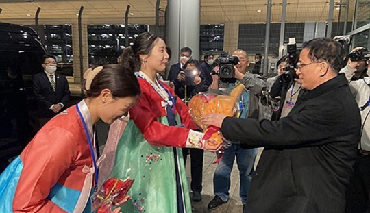 한복을 입은 재일본조선인총연합회(조총련) 여성들이 25일 도쿄 하네다공항에 도착한 북한 여자축구 대표팀 관계자에게 꽃다발을 전달하고 있다.<연합뉴스>